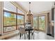 Bright dining area with large windows providing scenic views, a modern chandelier, and access to the outdoors at 779 Aspen Way, Evergreen, CO 80439
