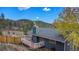 An exterior elevation of a home with a wood deck surrounded by mature trees at 779 Aspen Way, Evergreen, CO 80439