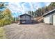 Charming home with gravel driveway, a wraparound deck and a detached garage at 779 Aspen Way, Evergreen, CO 80439