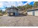 Exterior view of home with large front windows, wrap-around deck, and an oversized detached two-car garage at 779 Aspen Way, Evergreen, CO 80439