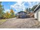 View of home and detached garage with trees and mountain background. Large yard and deck are also visible at 779 Aspen Way, Evergreen, CO 80439