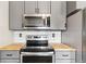 Well-lit kitchen with stainless steel appliances, grey cabinets, subway tile backsplash and butcher block countertops at 779 Aspen Way, Evergreen, CO 80439