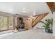 A spacious living room with carpet flooring, a stone fireplace, wood staircase and exterior access at 779 Aspen Way, Evergreen, CO 80439