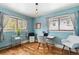Cozy office space with two windows, light blue walls, hardwood floors, and modern furniture at 779 Aspen Way, Evergreen, CO 80439