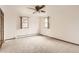 Spacious bedroom with two windows, carpet flooring and a vintage ceiling fan at 3270 S Krameria St, Denver, CO 80222