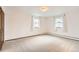 Bright and spacious bedroom with neutral carpet, radiator, and two windows at 3270 S Krameria St, Denver, CO 80222