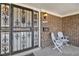 Cozy front porch area featuring an ornate security door, brick accents, and comfortable seating at 3270 S Krameria St, Denver, CO 80222