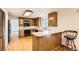 Traditional eat-in kitchen with wood cabinets, breakfast bar, and hardwood flooring at 3270 S Krameria St, Denver, CO 80222