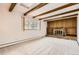 Cozy living room featuring a stone fireplace and wooden beams, perfect for relaxation at 3270 S Krameria St, Denver, CO 80222
