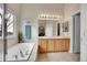 Bright main bathroom features a dual sink vanity, soaking tub, and large window at 271 Las Lomas St, Brighton, CO 80601