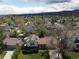 Neighborhood aerial view with solar panels on a house roof, a tree, and mountains in the background at 12622 W Radcliff Ave, Morrison, CO 80465