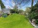 Spacious backyard with mature trees, lush green lawn, a garden, and partial fencing at 12622 W Radcliff Ave, Morrison, CO 80465