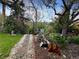 Idyllic backyard featuring a stone pathway, garden beds, and mature trees, creating a tranquil outdoor space at 12622 W Radcliff Ave, Morrison, CO 80465