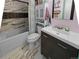 Bright bathroom featuring modern vanity, soaking tub, and decorative wall tiles at 12622 W Radcliff Ave, Morrison, CO 80465