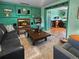 Inviting living room features a fireplace, wood paneling, and adjacent room with a bookcase at 12622 W Radcliff Ave, Morrison, CO 80465
