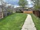 Scenic view of a walking path surrounded by lush greenery and wooden fences at 12622 W Radcliff Ave, Morrison, CO 80465