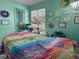 Inviting room with a massage table featuring a vibrant, colorful quilt and decorations at 12622 W Radcliff Ave, Morrison, CO 80465