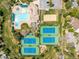 Aerial view of neighborhood amenities: pool, tennis courts, and sand volleyball, surrounded by mature trees at 7778 S Cherry Ct, Centennial, CO 80122