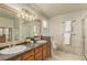 Bathroom features a dual sink vanity with a granite countertop, neutral tile, and enclosed shower at 7778 S Cherry Ct, Centennial, CO 80122