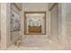 Luxurious bathroom featuring a soaking tub with brass fixtures, framed mirror, and travertine tile at 7778 S Cherry Ct, Centennial, CO 80122