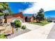 This home has a two-car garage, a green lawn, and mature landscaping at 7778 S Cherry Ct, Centennial, CO 80122