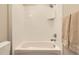 Clean white tub and shower with neutral tile and a showerhead at 10119 Bellwether Ln, Lone Tree, CO 80124