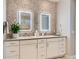Modern bathroom featuring dual sinks, stone accent wall, and illuminated mirrors at 10119 Bellwether Ln, Lone Tree, CO 80124