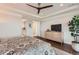 Bedroom with a ceiling fan, ensuite bathroom, flat screen TV, and hardwood floors at 10119 Bellwether Ln, Lone Tree, CO 80124