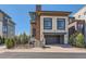 Contemporary home with stone accents, wood details, a covered entryway, and an attached two-car garage at 10119 Bellwether Ln, Lone Tree, CO 80124