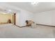 Spacious basement area with neutral carpet and chair with bench for seating at 7589 S Cove Cir, Centennial, CO 80122