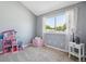 Neutral bedroom features window with light curtains, toy storage and a side table at 7589 S Cove Cir, Centennial, CO 80122