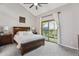 Bright bedroom with a large bed, ceiling fan, and sliding glass door leading to a deck at 7589 S Cove Cir, Centennial, CO 80122