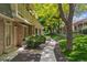 Well-manicured townhouse exterior featuring a stone pathway and mature landscaping at 7589 S Cove Cir, Centennial, CO 80122