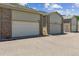 Exterior shot of attached garages, showcasing brick accents and clean white doors at 7589 S Cove Cir, Centennial, CO 80122