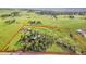 Aerial view of a large home surrounded by green space, mature trees, and custom built motocross track at 1353 S Elbert St, Elizabeth, CO 80107