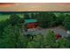Aerial view of a log cabin home surrounded by lush green trees and open fields at 1353 S Elbert St, Elizabeth, CO 80107