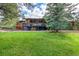 Log cabin home with a covered deck and a large lawn surrounded by trees at 1353 S Elbert St, Elizabeth, CO 80107