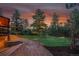 Scenic backyard featuring a log home, manicured lawn, and mature trees at 1353 S Elbert St, Elizabeth, CO 80107