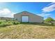Exterior view of metal building with a large roll-up door on a grassy lot at 1353 S Elbert St, Elizabeth, CO 80107