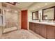 Bathroom featuring double vanity sinks and tiled walk-in shower at 1353 S Elbert St, Elizabeth, CO 80107