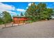 Log cabin with garage and a gravel driveway, nestled in a wooded area at 1353 S Elbert St, Elizabeth, CO 80107