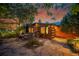 Charming log cabin home with stone patio and lush landscaping at sunset at 1353 S Elbert St, Elizabeth, CO 80107