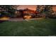 Beautiful sunset view of a log cabin home with a large lawn and mature trees at 1353 S Elbert St, Elizabeth, CO 80107