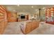 Open living room with log walls, tile floors, wood-burning fireplace, and built-in shelving for ample storage at 1353 S Elbert St, Elizabeth, CO 80107