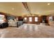 Spacious main bedroom featuring log walls, a wood-burning stove, and ample natural light from multiple windows at 1353 S Elbert St, Elizabeth, CO 80107