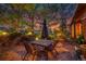 Inviting outdoor dining area with stone pavers, lit trees, and comfortable seating creating a relaxing ambiance at 1353 S Elbert St, Elizabeth, CO 80107