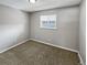 A gray-painted bedroom with a window and neutral carpet flooring at 3957 S Boston St, Denver, CO 80237