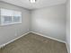 A gray-painted bedroom with a window and neutral carpet flooring at 3957 S Boston St, Denver, CO 80237