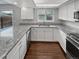 Well-lit kitchen showcases granite counters, modern stainless-steel appliances, and sleek white cabinetry at 3957 S Boston St, Denver, CO 80237