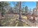Spacious backyard with rock garden accents, mature trees, and a wooden fence offering privacy at 2488 W 111Th Pl, Denver, CO 80234